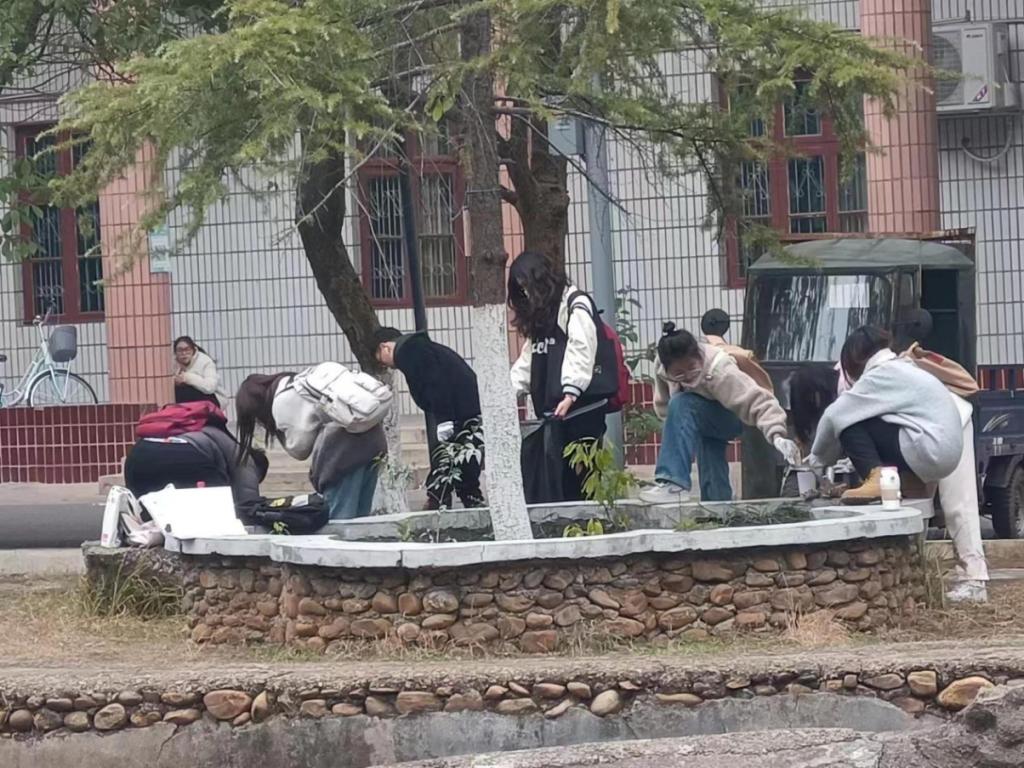 同學們在花壇周圍拾白色垃圾