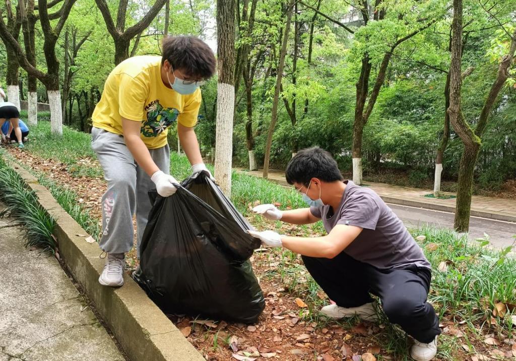 同學們將落葉拾入垃圾袋中