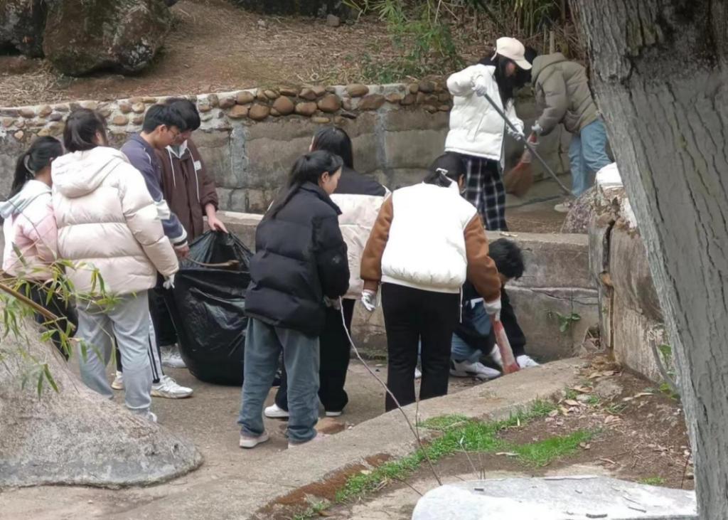 同學們合力把落葉裝進垃圾袋