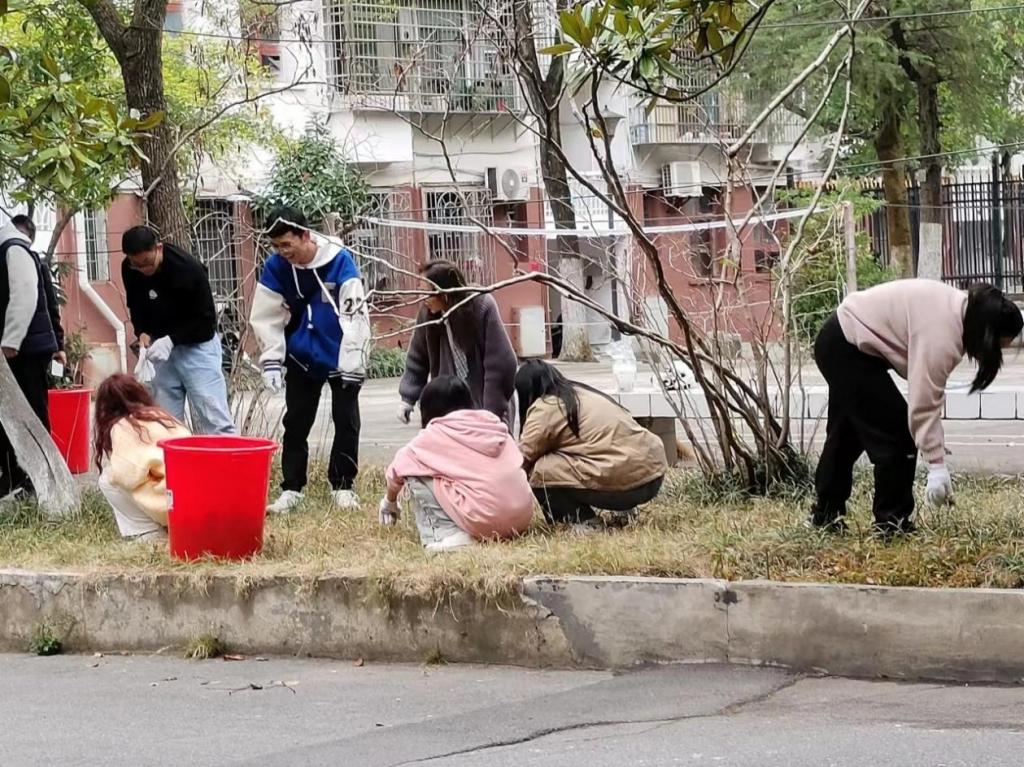 同學(xué)們正在用手認(rèn)真撿拾草坪里的垃圾