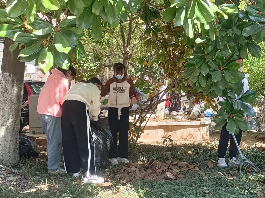 同學(xué)們合力將落葉裝進(jìn)垃圾袋