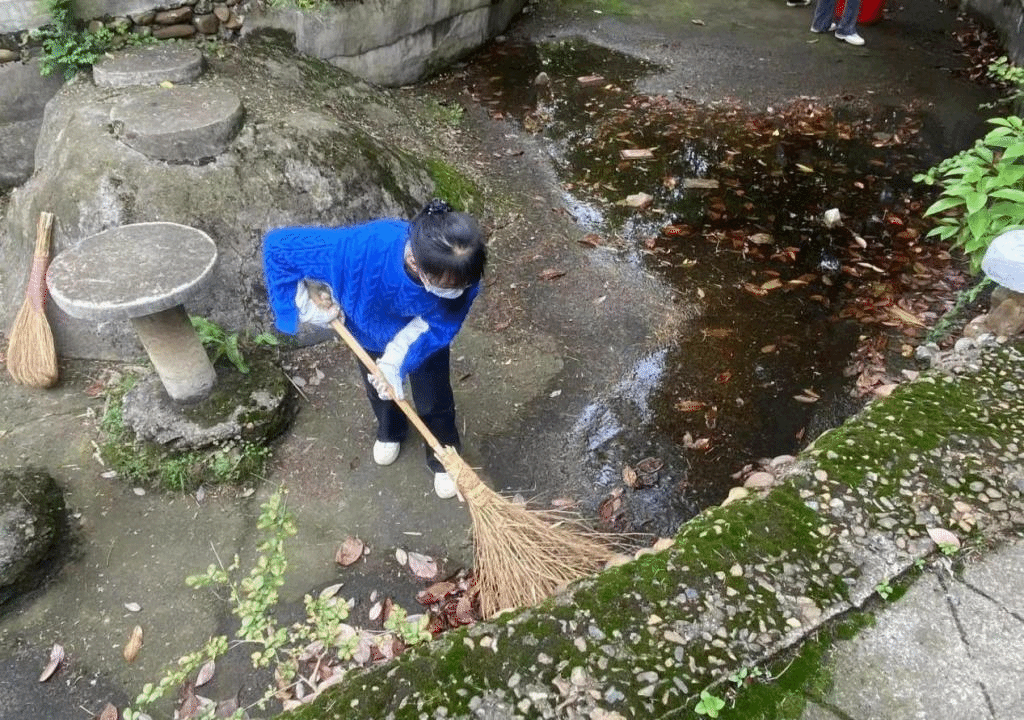 同學(xué)們打掃水池中的樹葉