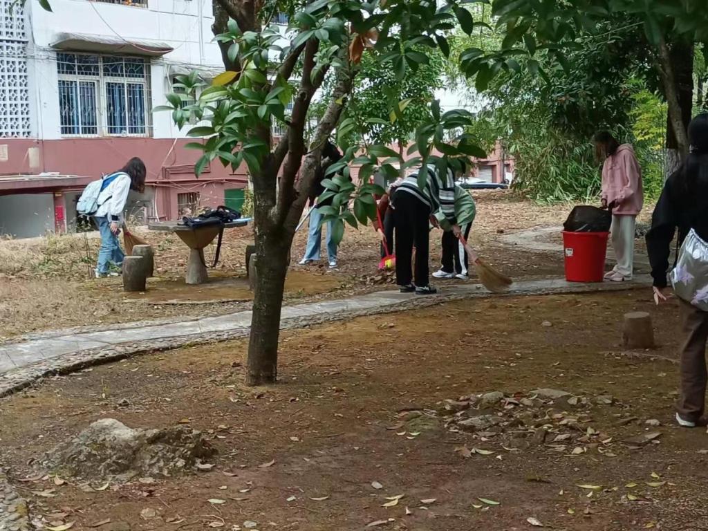 同學(xué)們正在合力清理落葉